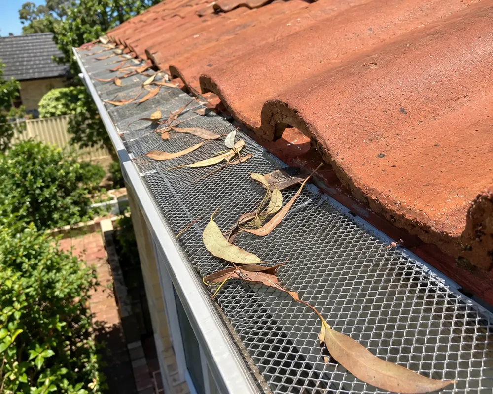 Gutter guards Perth: aluminium gutter guard mesh over a gutter with gum leaves sitting on top, terracotta tiles